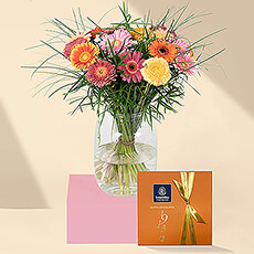 Put a smile on someone's face with a delightful bouquet of fresh Gerbera daisies in bright sorbet colors. A cheerful orange gift box filled with delicious Leonidas chocolates is the perfect companion to the colorful flowers.
