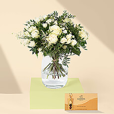 This beautiful bouquet of white roses has a fresh, classic style that is certain to please. An iconic Godiva Gold gift box with 8 scrumptious Belgian chocolates accompanies the bouquet. White roses and Belgian chocolate are a perfect gift idea for weddings, engagements, birthdays, and anniversaries.