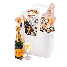 A handy reusable Koziol "Taschelino" white tote is filled with a delicious collection of Dutch cheese, gourmet crisps, Belgian chocolates, and Champagne for a picnic on the go.