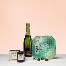 A gift basket with a fragrant scented candle, a bottle of high-quality cava, and tasty Belgian chocolates is the ideal present for every bon vivant.