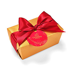 The timeless Godiva Gold Ballotin is all dressed up with a rich red satin ribbon. Untie the beautiful ribbon and unwrap the shimmering gold paper to reveal this exciting gift ballotin filled to the brim with the very best Godiva chocolates.