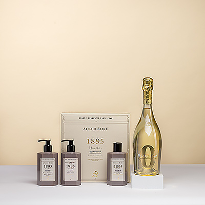 Presenting a gift set for pure pampering by the luxurious French brand Atelier Rebul. A stylish gift box with hand soap, shower gel, and lotion is paired with a delicious bottle of non-alcoholic Bottega Zero Sparkling Life.