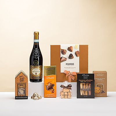 Los placeres del vino italiano tinto rubí y los chocolates belgas de primera calidad y otros dulces se combinan en este elegante regalo. El vino Dezzani 'Appassimento' Rosso es maravilloso para saborear con lujosos pralinés de chocolate belga Neuhaus, trufas Godiva, tabletas de chocolate y perlas de capuchino, ricos macarons y mucho más.