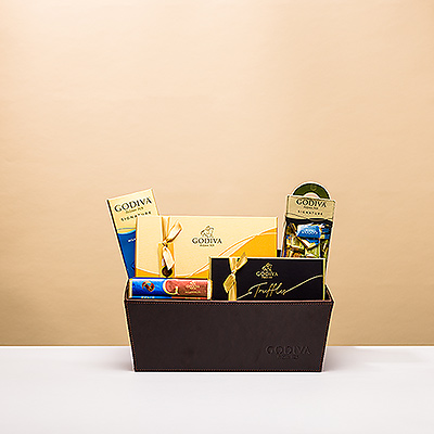 Découvrez la richesse et la variété des légendaires chocolats Godiva dans un luxueux panier cadeau en cuir. Gâtez vos amis et votre famille avec cette impressionnante collection de créations Godiva au chocolat belge au lait, noir et blanc.