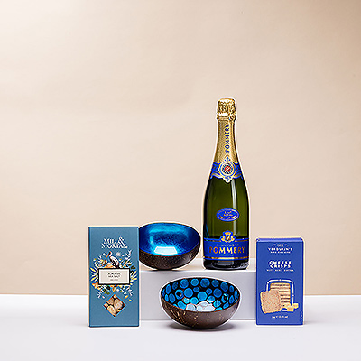 Abre una elegante botella de champán Pommery Brut para un aperitivo con amigos. El fino burbujeante se presenta con unos preciosos platos azules hechos a mano y aperitivos salados.