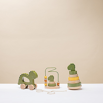 ¡Empieza el recreo! Este trío de juguetes clásicos de madera se ha renovado con un simpático diseño de dinosaurio. Las anillas apilables, los juguetes de tracción y el laberinto de cuentas garantizan horas de diversión para los más pequeños, a la vez que desarrollan la motricidad fina.