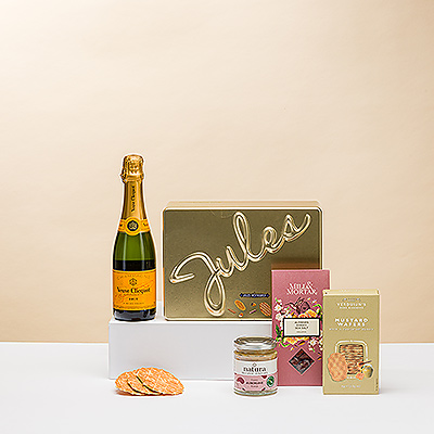 Summer is the perfect time to enjoy bubbly Champagne with elegant sweet and salty snacks. This summer gift pairs an exquisite 37.5 cl bottle of iconic Veuve Clicquot Yellow Label Brut Champagne with delicious biscuits, crunchy honey sea salt almonds, mustard honey wafer crackers, and organic eggplant cumin spread.